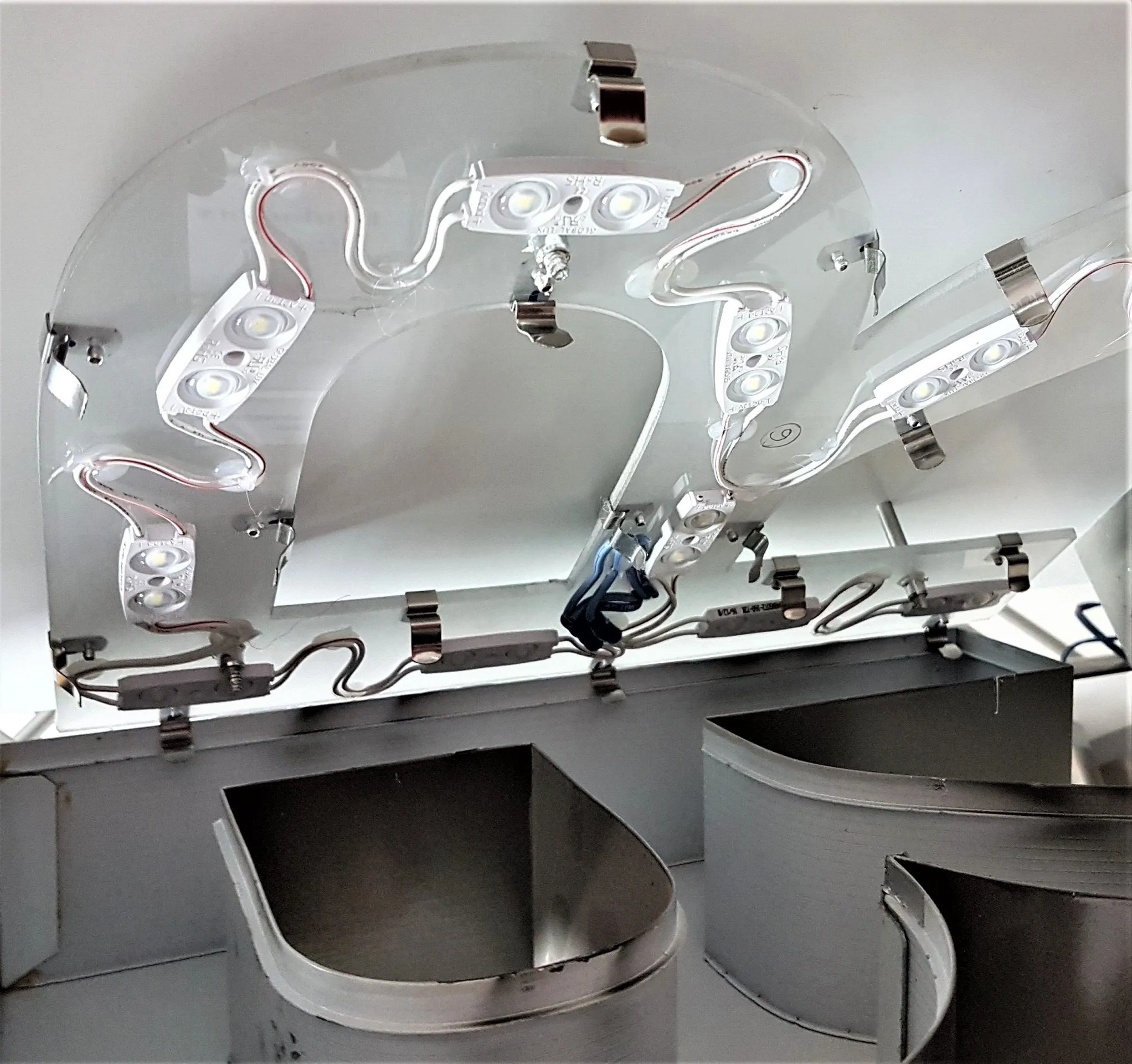 Stainless steel clips holding LED modules to the back of an Ascent channel letter