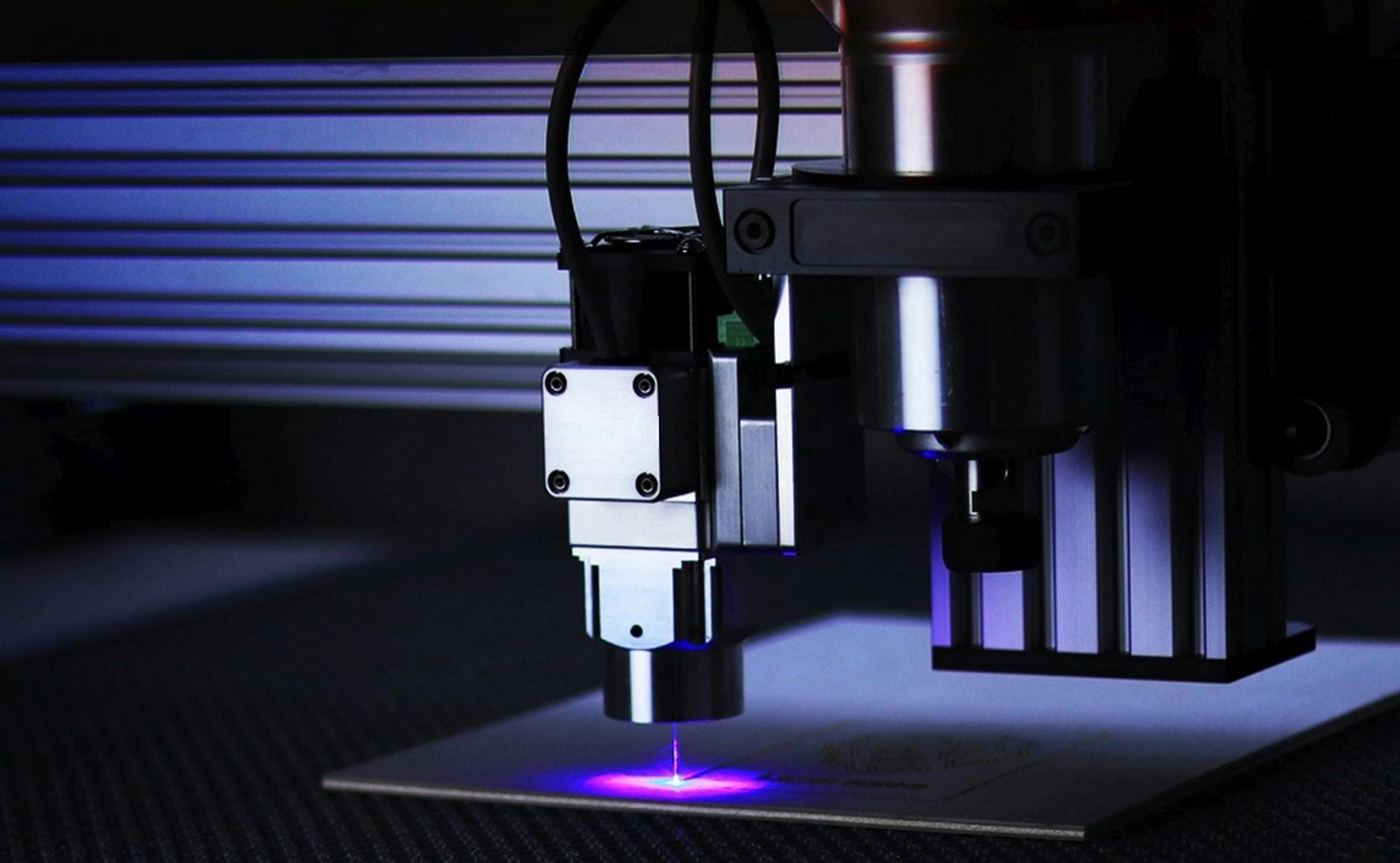 CO2 laser cutter — close-up of laser head in operation