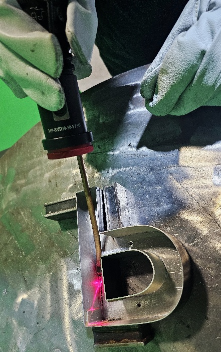 Operator welding a small 4-inch channel letter using a QCW laser welder